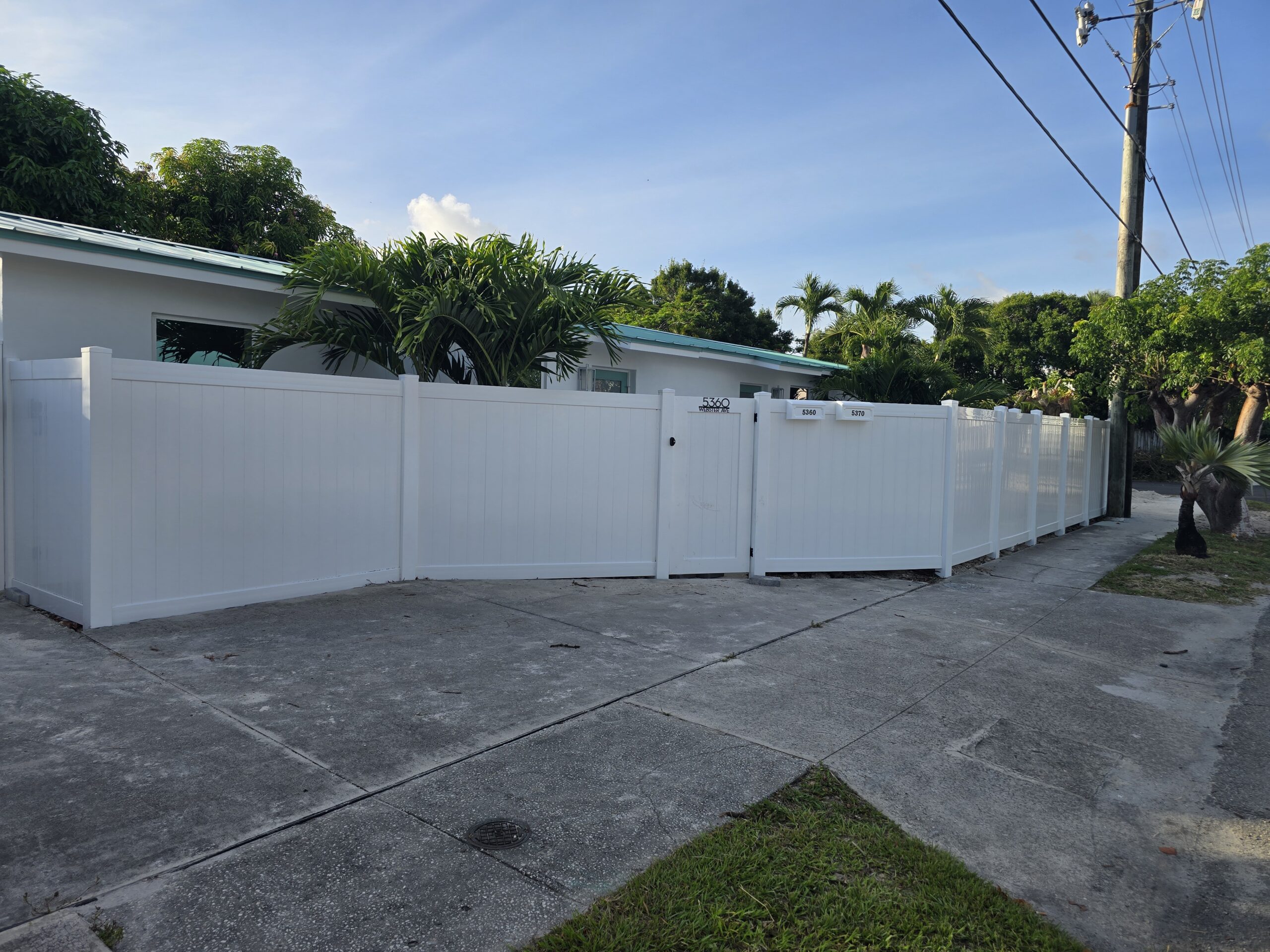 White PVC privacy fence with custom access gate installed by Pick-It Fence Company in Palm Beach Island, Florida.